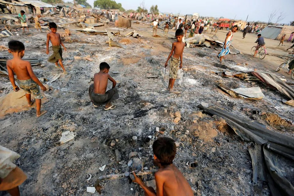 PADANG JARAK PADANG TERKUKUR: Budak-budak lelaki ini kelihatannya sedang mencari barangan yang masih boleh digunakan di sebalik kemusnahan dan abu rumah-rumah yang terbakar di kem petempatan sementara bagi masyarakat Muslim Rohingya di barat Negeri Rakhine berdekatan Sittwe, Myanmar. - Foto REUTERS