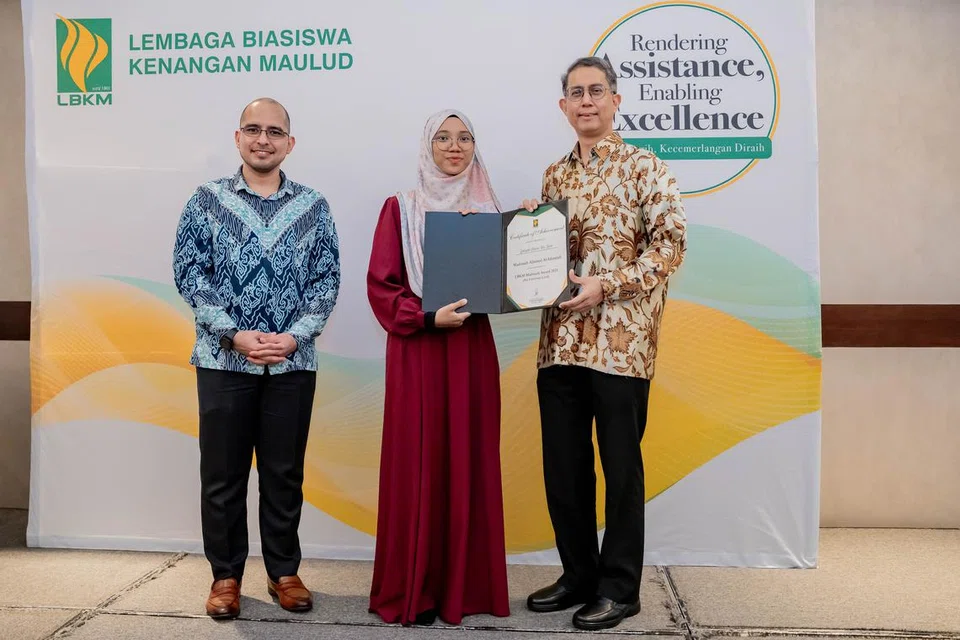 Cik Zakiyah Hanim Zaini (tengah) menerima Anugerah Madrasah LBKM daripada Menteri Negara (Ehwal Dalam Negeri merangkap Pembangunan Negara), Profesor Madya Dr Muhammad Faishal Ibrahim (kanan), diiringi Presiden LBKM, Dr Syed Harun Taha Al-Habsyi (kiri).