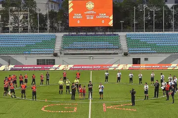 JASA DIKENANG: Golongan peguam berkumpul dalam satu perlawanan bola sepak bagi mengenang jasa mendiang Encik G. Kannan, pengarah kanan dan penasihat undang-undang negara kanan di AGC, yang meninggal dunia bulan lalu. Hadirin memberi tepukan selama seminit sebelum perlawanan di Stadium Jalan Besar itu bermula. - Foto BH oleh DESMOND WEE