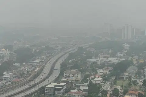 DITUTUPI JEREBU: Kawasan perumahan dan komersial di Kuala Lumpur diselubungi asap yang berpunca daripada kebakaran hutan di Sumatera dan Kalimantan. - Foto AFP