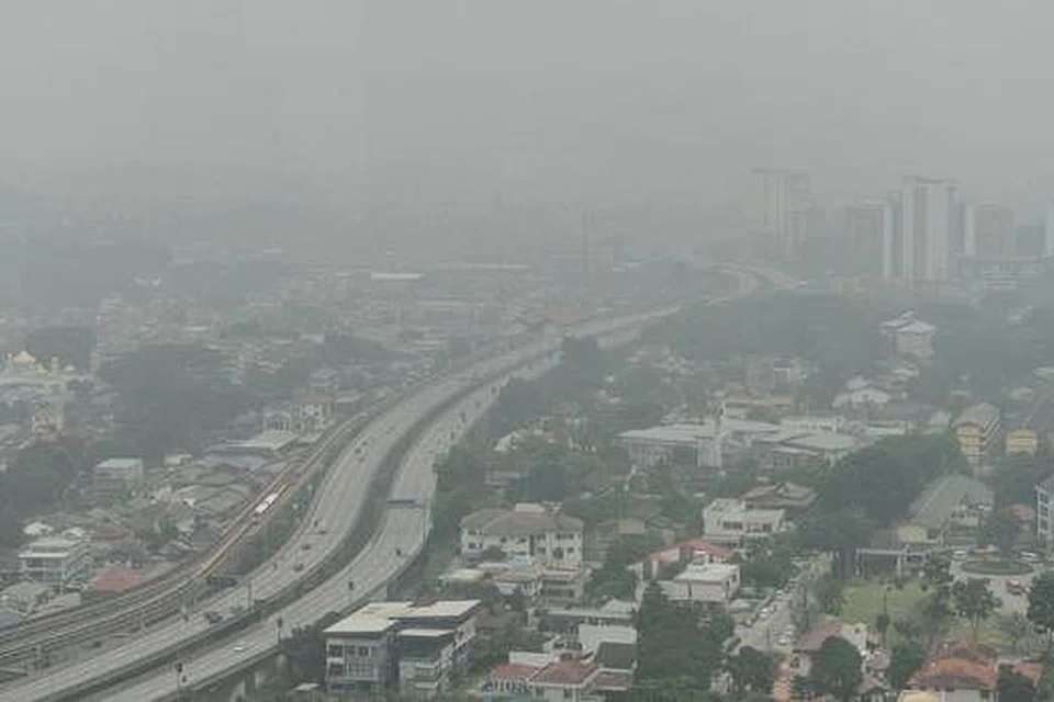 DITUTUPI JEREBU: Kawasan perumahan dan komersial di Kuala Lumpur diselubungi asap yang berpunca daripada kebakaran hutan di Sumatera dan Kalimantan. - Foto AFP