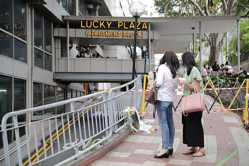 DI TEMPAT KEMALANGAN: Jambangan bunga kelihatan diletakkan di tempat kemalangan yang berlaku di luar Lucky Plaza yang menyebabkan sebuah kereta terhumban dan dua pembantu rumah Filipina terbunuh dan beberapa orang lagi cedera kelmarin. - Foto BH oleh GIN TAY