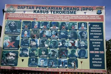 PENGGANAS DIKEHENDAKI: Papan tanda yang dipasang polis Indonesia yang memaparkan wajah dan nama para individu, termasuk pengganas paling dikehendaki, Santoso, yang terlibat dalam kes-kes terorisme di Poso, Sulawesi Tengah. - Foto REUTERS
