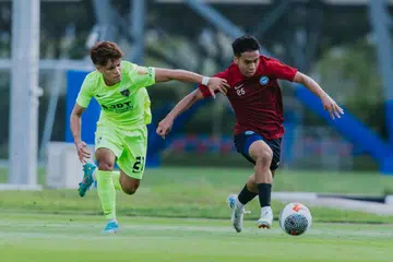 Farhan Zulkifli (kanan) cuba melepaskan diri daripada halangan pemain Johor Darul Takzim, Nazmi Faiz, dalam perlawanan persahabatan di Hab Bola Sepak Kallang pada 7 September.