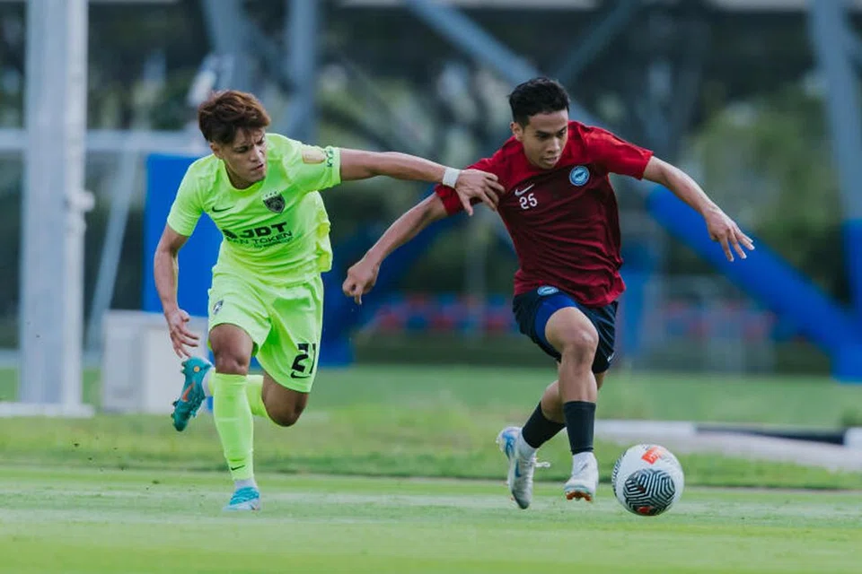 Farhan Zulkifli (kanan) cuba melepaskan diri daripada halangan pemain Johor Darul Takzim, Nazmi Faiz, dalam perlawanan persahabatan di Hab Bola Sepak Kallang pada 7 September.