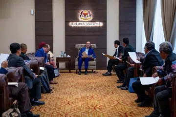 Perdana Menteri Malaysia, Datuk Seri Anwar Ibrahim (tengah) memenuhi tuntutan jadualnya di Parlimen Malaysia pada hari pertama Persidangan Dewan Rakyat pada 14 Oktober. 