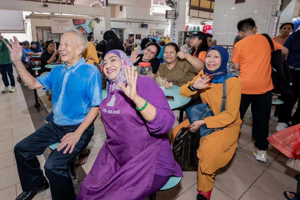 SERONOK BERKENALAN: Encik Ng Kok Song beramah mesra dan bergambar bersama para peniaga di Pasar Geylang Serai
