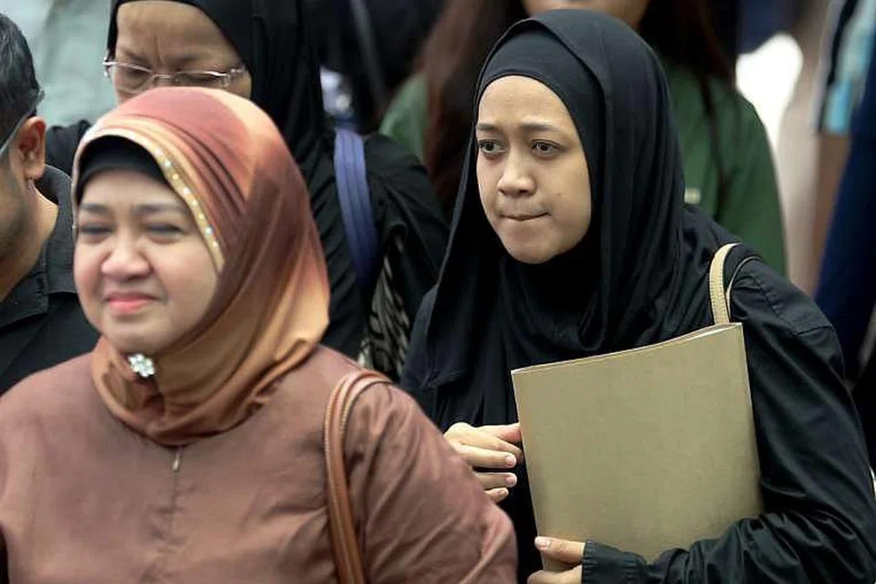 Cik Nurul Asyikin (belakang), bersama ibunya, Cik Juraidah Nabi, menggunakan selimut untuk memadamkan api yang menyelubungi suami beliau, Allahyarham Mohd Rizalludin Hassan. 