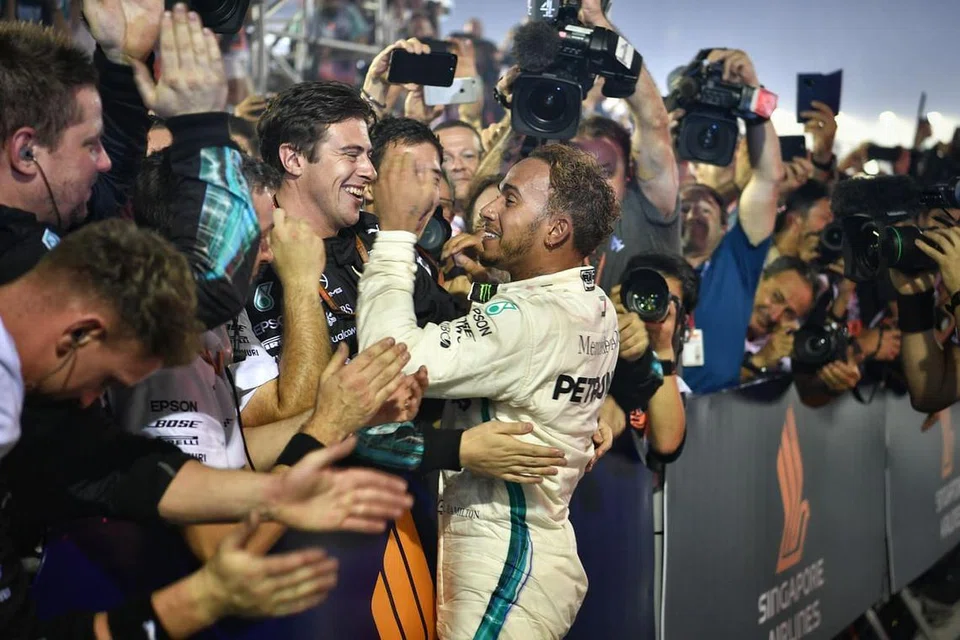 KEJAYAAN DEMI KEJAYAAN: Hamilton meraikan kemenangan di Grand Prix Singapura pada 2018 dengan anggota krunya. Beliau memenangi kejuaraan dunia yang kelima pada tahun itu. - Foto fail 