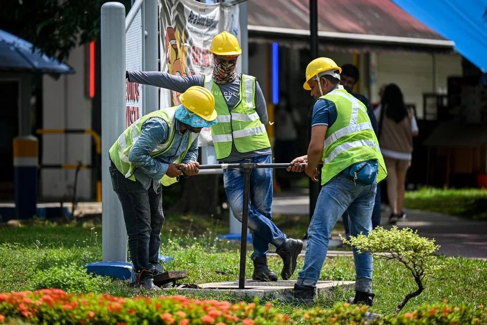 Tiga pekerja melakukan penyenggaraan paip air pada lubang jalan, agar ia dapat berfungsi dengan baik.