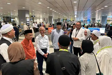 SAMBUT JEMAAH: Menteri Bertanggungjawab bagi Ehwal Masyarakat Islam, Encik Masagos Zulkifli Masagos Mohamad (lengan panjang), bersama Presiden Majlis Ugama Islam Singapura (Muis), Encik Saat A. Rahman (di kanannya) dan Ketua Eksekutif Muis, Encik Kadir Maideen (di kirinya) menyambut pulang jemaah haji di Lapangan Terbang Changi