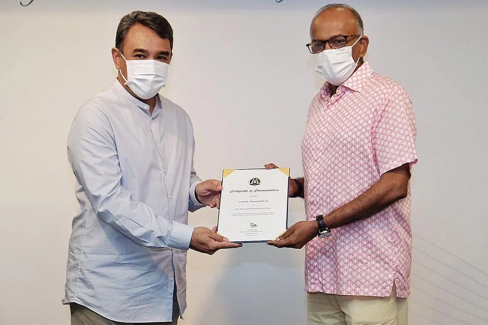 SUMBANG MASA, SUMBER: Encik Shanmugam menyampaikan sijil kepujian kepada Naib Pengerusi RRG, Ustaz Dr Mohamed Ali, yang merupakan antara sekumpulan relawan yang telah menyumbang masa dan sumber untuk membimbing dan memberi kaunseling kepada tahanan, individu di bawah penyeliaan serta keluarga mereka. - Foto BH oleh KHALID BABA 