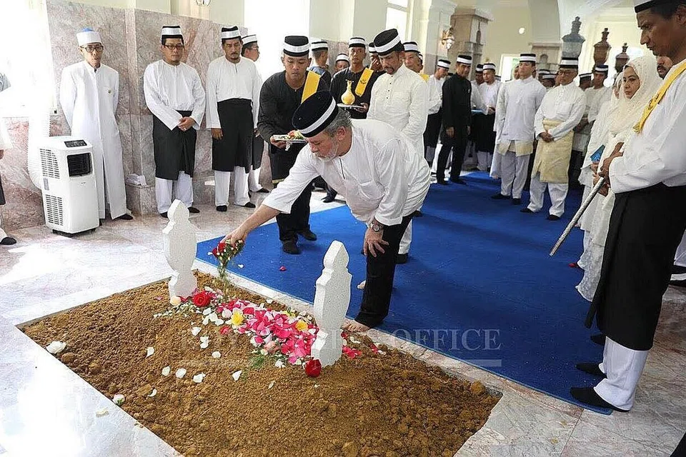 UCAP SELAMAT TINGGAL: Sultan Ibrahim menabur bunga atas pusara ibunya, Yang Amat Mulia Enche' Besar Hajah Khalsom Abdullah yang meninggal dunia baru-baru ini, dengan disaksikan Sultan Brunei, Sultan Hassanal Bolkiah (di belakang beliau). - Foto FACEBOOK SULTAN IBRAHIM/THE STAR