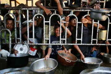Kanak-kanak Palestin menunggu makanan di sebuah dapur amal di kawasan Mawasi, Khan Yunis, selatan Jaluran Gaza pada 22 Julai 2025. Ketua hospital terbesar di Gaza memaklumkan bahawa seramai 21 kanak-kanak telah meninggal dunia akibat kekurangan zat makanan dan kebuluran dalam tempoh tiga hari lalu, di tengah-tengah serangan dahsyat oleh tentera Israel. 