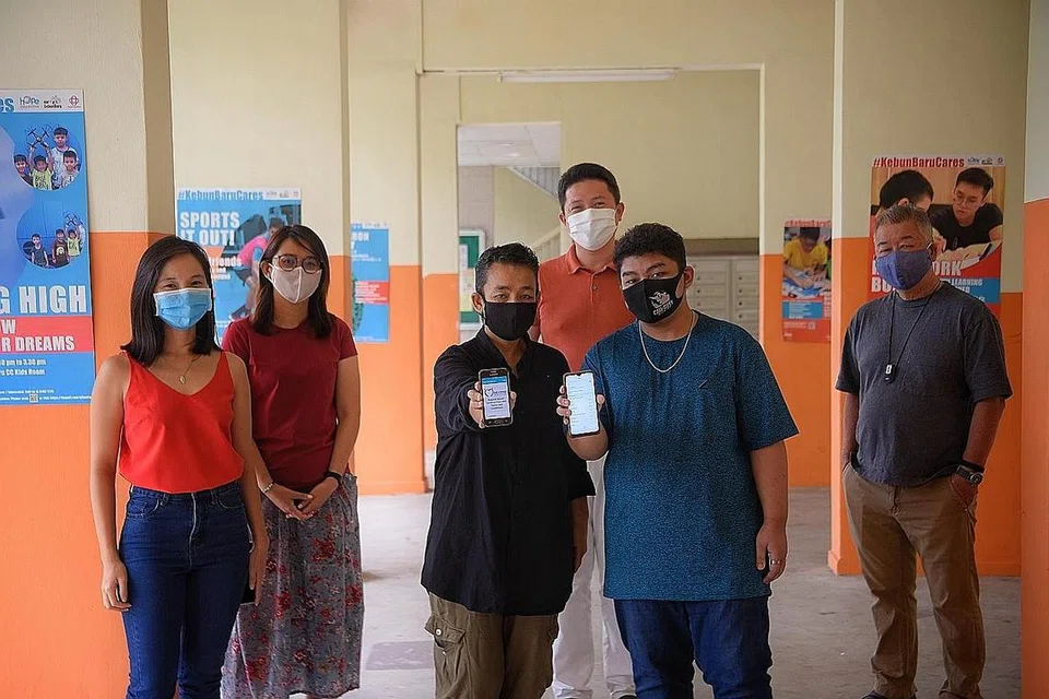 GUNA WIFI PERCUMA DI BAWAH BLOK: Cik Siti Aidah Abdullah (pegang telefon bimbit, kiri) dan anaknya, Mohamed Shazwan Mohamed Awal, 17 tahun, menggunakan WiFi percuma di bawah blok mereka hasil daya usaha yang dipimpin Cik Rebecca Chiu (paling kiri) dan disokong Anggota Parlimen Kebun Baru, Encik Henry Kwek (tengah, belakang). Mereka disertai Cik Tan Hooi Boon, ketua pasukan untuk Program Beyond Social Services Youth United (kejiranan Ang Mo Kio) dan pengarah eksekutif Beyond Social Services, Encik Gerard Ee. - Foto BH oleh MARK CHEONG