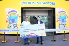 Ketua Pegawai Eksekutif COURTS, Encik Harry Higashiura (kanan), menyerahkan ‘cek’ kepada penasihat pertubuhan akar umbi GRC East Coast, Encik Tan Kiat How (kiri), semasa sambutan ulang tahun ke-50 COURTS di COURTS Megastore@Tampines pada 7 Disember.