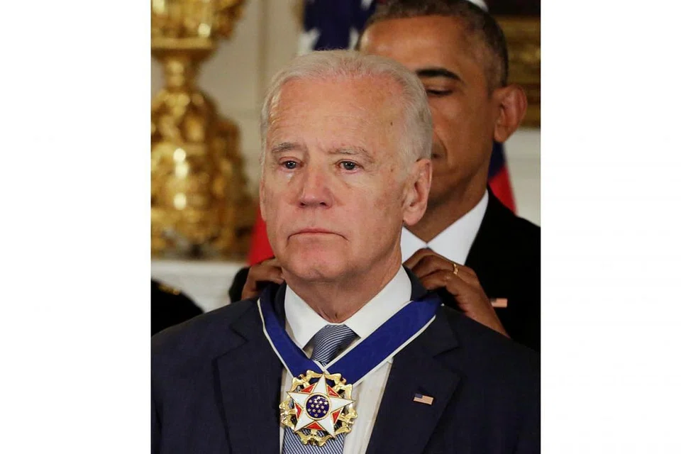 TERHARU: Naib Presiden Amerika Syarikat Joe Biden (depan) menitiskan air mata selepas Encik Obama (belakang) memberinya Pingat Kebebasan Cemerlang Presiden di Rumah Putih, Washington DC, semalam. - Foto AFP