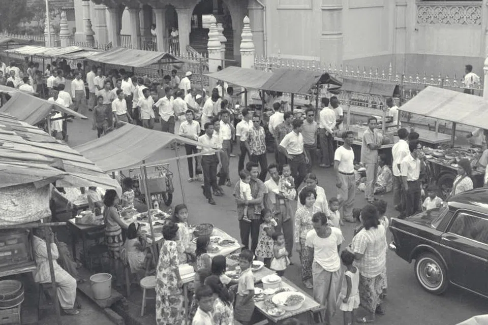 Orang ramai sibuk memilih dan membeli kuih-muih serta makanan lain dari gerai sementara di kawasan Kampung Jawa yang diadakan semasa Ramadan, dalam gambar yang dirakamkan pada 1965 ini. Tradisi menjual makanan di jalan raya sekitar Masjid Sultan terus diadakan sehingga kini. 