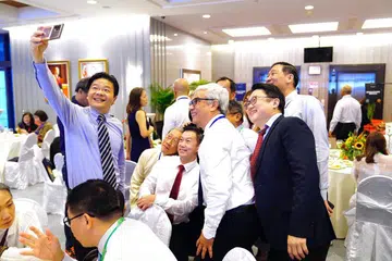 BERINTERAKSI: Timbalan Perdana Menteri, Encik Lawrence Wong (berdiri, kiri) bergambar bersama hadirin semasa menghadiri Upacara Pelantikan Majlis North West di Bangunan Parlimen pada Sabtu.