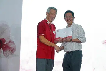 SUMBANGAN DIIKTIRAF: Dr Abdul Razakjr (kanan) menerima Anugerah Bakti Setia bagi khidmatnya kepada masyarakat sebagai pemimpin akar umbi daripada PM Lee. - Foto FACEBOOK LEE HSIEN LOONG