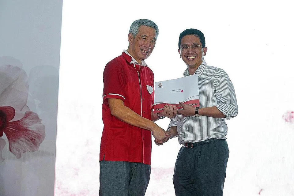 SUMBANGAN DIIKTIRAF: Dr Abdul Razakjr (kanan) menerima Anugerah Bakti Setia bagi khidmatnya kepada masyarakat sebagai pemimpin akar umbi daripada PM Lee. - Foto FACEBOOK LEE HSIEN LOONG
