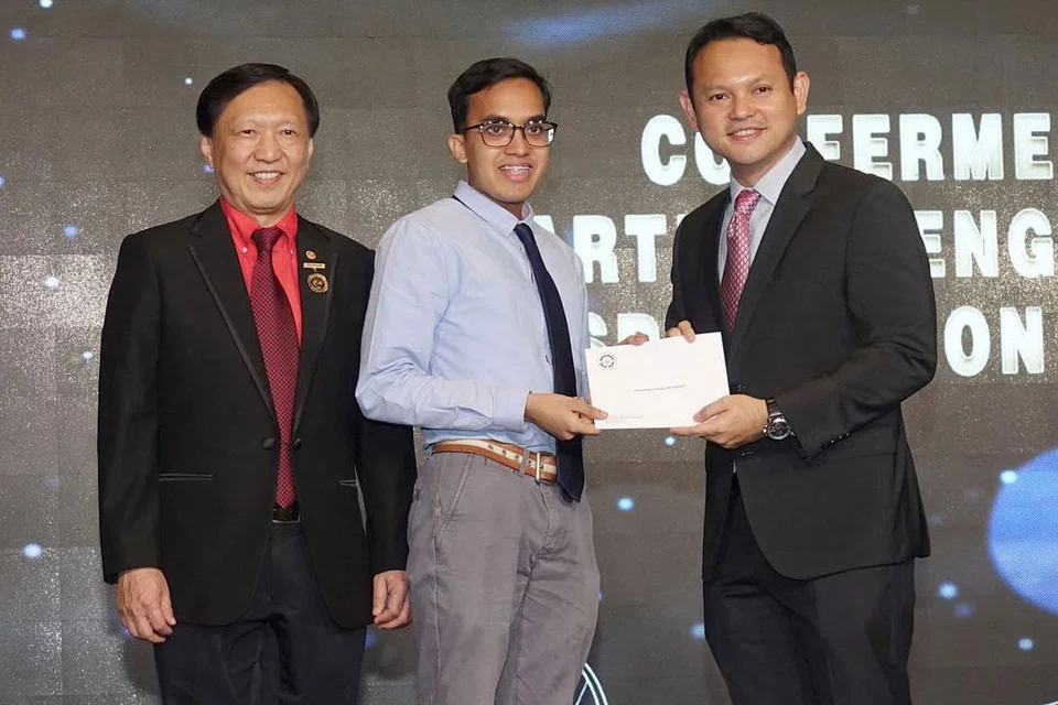 RANGSANG BIDANG KEJURUTERAAN: Mahasiswa dari Universiti Nasional Singapura (NUS) Encik Muhammad Hudzaifah Sulaiman dan Encik Mohamed Taufik Rahim dari Politeknik Temasek (gambar atas) menerima anugerah biasiswa Institusi Jurutera Singapura (IES)-Yayasan Mendaki daripada Encik Zaqy Mohamad (paling kanan) dan Presiden IES, Profesor Yeoh Lean Weng di Majlis Makan Malam IES ke-52 dan Jamuan Penutup Persekutuan Pertubuhan Kejuruteraan Asean (AFEO) ke-36 di Resorts World Sentosa kelmarin. - Foto IES