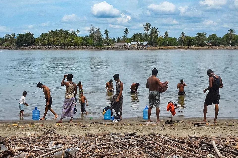 NASIB PELARIAN: Sekumpulan kaum Rohingya mandi di pantai Pulau Idaman, sebuah pulau kecil di timur Aceh, di utara Sumatra pada 5 Jun lalu, sehari selepas kira-kira 80 daripada mereka mendarat di perairan pulau tersebut. - Foto AFP