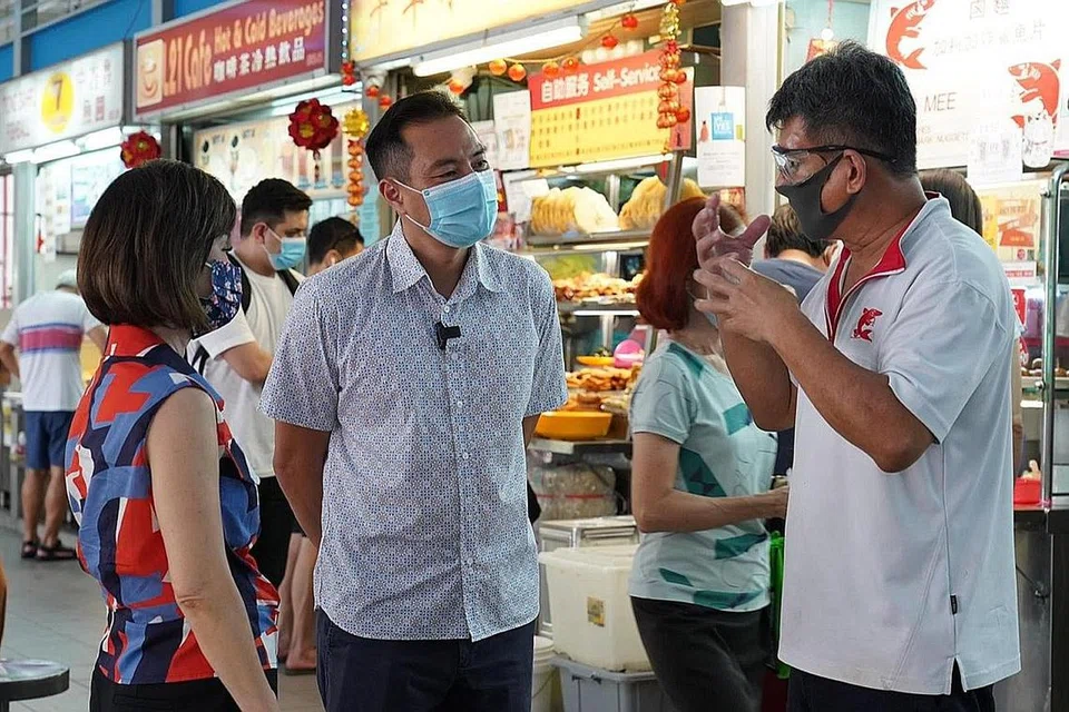 MANFAATKAN KHIDMAT PENGHANTARAN: Dr Khor dan Encik Tan (tengah) berbual bersama Encik Sim, seorang penjaja yang sebelum ini ragu-ragu untuk menggunakan perkhidmatan penghantaran tetapi sekarang menggunakan wadah itu, yang telah banyak membantu perniagaannya. - Foto MCI