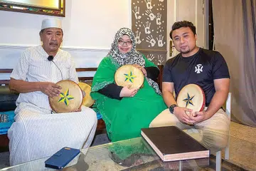 TERUSKAN USAHA MASYARAKATKAN HADRAH: (Dari kiri) Guru Firqatul Wannazam, Encik Othman Abdul Rahman; berusaha memajukan seni tradisional dengan bantuan anaknya yang juga penasihat kumpulan, Cik Fadilah Othman, dan pengurus serta khalifah kumpulan, Encik Muhammad Shahid Haron. - Foto BM oleh ZALEHA ABDUL KADER