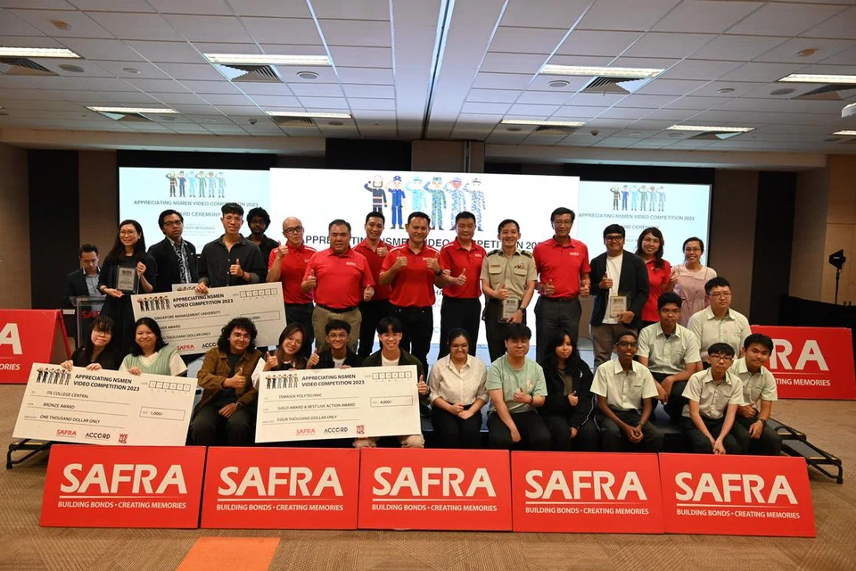 MAJLIS ANUGERAH: Menteri Negara Kanan (Pertahanan merangkap Tenaga Manusia) dan Presiden Safra, Encik Zaqy Mohamad (barisan belakang, tujuh dari kanan), bergambar bersama pemenang-pemenang Pertandingan Video Menghargai NSmen di Safra Toa Payoh pada Selasa.