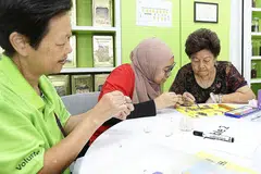 MENYUMBANG TENAGA: Cik Nadiah (tengah, gambar kanan) meluangkan masa cuti sekolahnya sebagai sukarelawan. Beliau menganggap menggunakan seni dalam kerja sukarela adalah sesuatu yang segar.