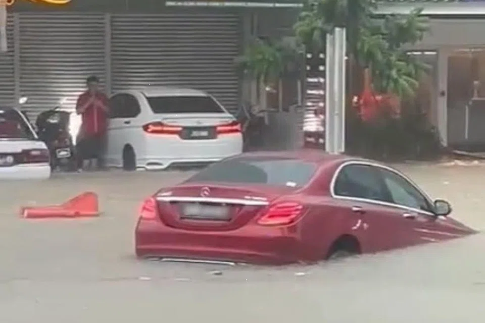 AKIBAT BANJIR: Sebuah kereta Mercedes yang mempunyai nombor plat Singapura kelihatan dibawa arus banjir berhampiran pusat beli-belah KSL City Mall.