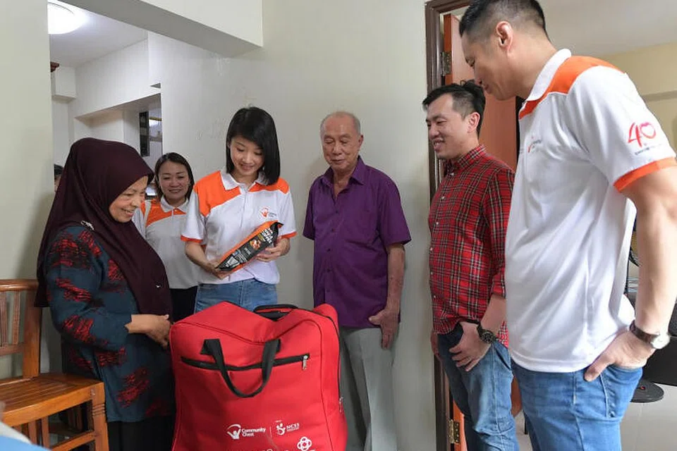 (paling kiri) Cik Rohani Rajab, 68 tahun menerima pakej perayaan dari (tengah) Cik Sun yang melawatnya di flatnya di Punggol semalam. Cik Sun ditemani oleh (tiga dari kanan) Encik Loh; Dr Don Chen, Pengarah (Pendidikan dan Pembangunan Perniagaan) G.H.Y Culture & Media (Singapore) Ltd serta Encik Danny Koh, Pengerusi bersama Jawatankuasa Community Chest Fu Dai 2023, 50820127 