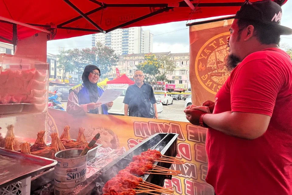 Penolong Pegawai Tadbir Jabatan Pelesenan dan Pembangunan Usahawan Majlis Perbandaran Ampang Jaya, Selangor (kiri), memeriksa lesen peniaga di Bazar Ramadan Keramat Permai. Bazar di bawah seliaan Majlis Perbandaran Ampang Jaya ini buat kali pertama beroperasi lebih awal iaitu bermula 27 Februari.