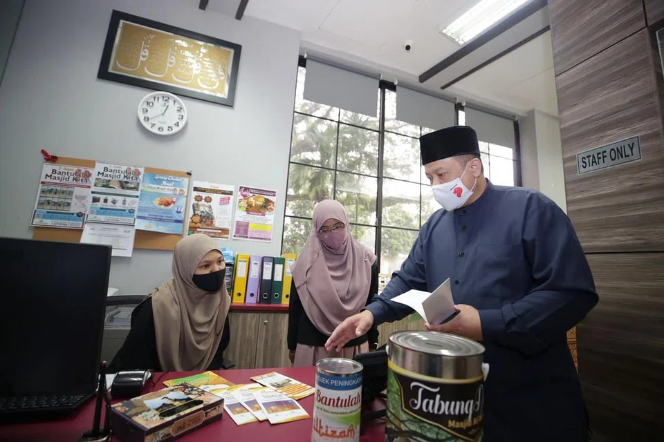 Pengerusi Masjid Al-Amin, Haji Muhammad Khairul Jameel Yahya (bersongkok), berbincang bersama kakitangan masjid. - Foto BH oleh TIMOTHY DAVID