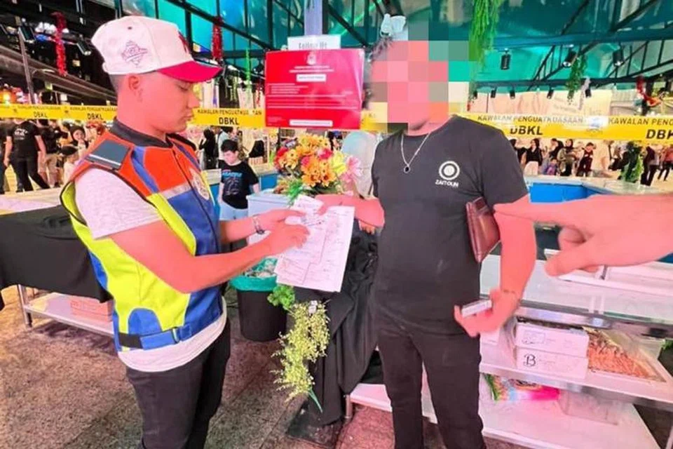 TIADA KOMPROMI: Kakitangan Dewan Bandaraya Kuala Lumpur (DBKL) menjelaskan kesalahan yang dilakukan kepada pekerja premis menjual manisan Arab di Bukit Bintang yang dikompaun dan diarah tutup serta-merta kerana beroperasi tanpa lesen.