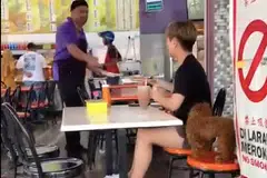 Tangkap layar seorang lelaki memesan makanan dan minuman di sebuah restoran mamak di Segamat Baru, Segamat, sambil ditemani anjing.