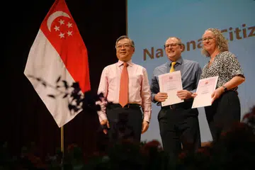 WARGA BARU: Cik Stacey Deborah Tucker dan Encik Nelius Strydom bersama Menteri Perdagangan dan Perusahaan, Encik Gan Kim Yong (kiri), di Majlis Kewarganegaraan Kebangsaan 2023 di ITE Kolej Barat pada 13 Ogos 2023.