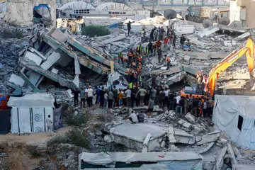 Penduduk berkumpul ketika anggota Pertahanan Awam berusaha menyelamatkan mangsa yang terperangkap di bawah runtuhan sebuah bangunan kediaman enam tingkat di Bandar Gaza pada 16 September. Bangunan yang dilaporkan mengalami kerosakan akibat serangan Israel sebelum ini runtuh ketika menempatkan keluarga yang kehilangan tempat tinggal, menyebabkan sekurang-kurangnya 12 orang terbunuh, termasuk lima kanak-kanak, manakala puluhan lagi dikhuatiri masih terperangkap