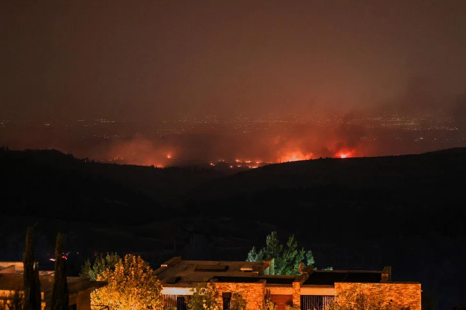 Api dan asap menjulang ketika kebakaran hutan marak susulan cuaca panas melampau dan angin kencang di Neve Ilan, Israel.