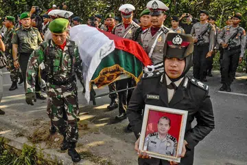 UPACARA PENGEBUMIAN: Anggota pasukan polis Indonesia mengusung keranda pegawai yang terkorban dalam serangan pengganas ke atas sebuah ibu pejabat polis di Pekanbaru. - Foto AFP