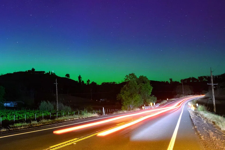 Cahaya aurora berwarna hijau dan biru menghiasi langit malam di lebuh raya di utara San Francisco, di Middletown, California pada 11 Mei.  