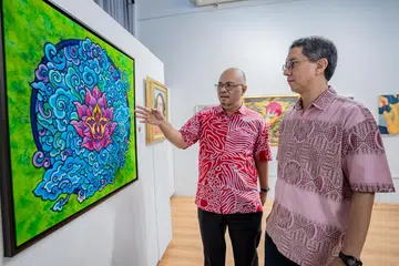KARYA TEKNOLOGI: Profesor Madya Dr Muhammad Faishal Ibrahim (kanan) mengamati salah sebuah lukisan dalam pameran, Seni Kita 2023, bersama penganjur bersama yang juga juri, Encik Kamal Dollah.