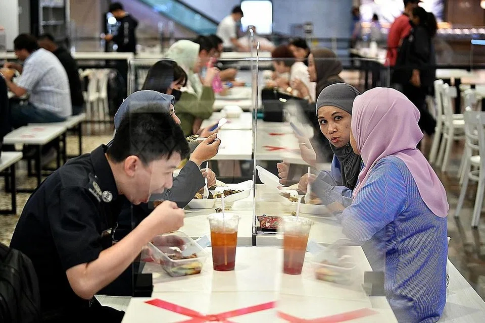 PATUH LANGKAH BERJAGA-JAGA: Kakitangan lapangan terbang menjamu selera di kawasan tempat makan staf di cawangan Kopitiam di Terminal 3, Lapangan Terbang Changi. Terminal 1 dan 3 dibuka semula kepada orang ramai pada 1 September lalu selepas tiga bulan ditutup ekoran langkah diperketat Covid-19 yang dikuatkuasakan di sana. - Foto BH oleh LIM YAOHUI