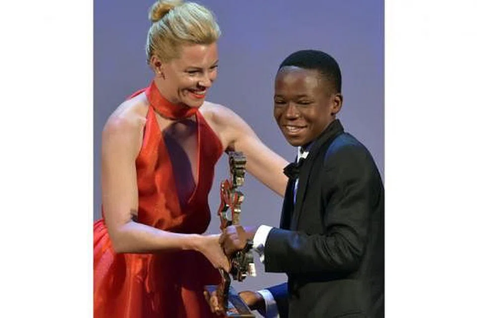 TERIMA ANUGERAH: Abraham Attah, yang tidak mempunyai pengalaman dalam bidang lakonan, menerima Anugerah Aktor Muda Terbaik Marcello Mastroianni di Festival Filem Venice 2015 di Italy daripada aktres dan pengarah filem Amerika Syarikat, Elizabeth Banks. - Foto AFP