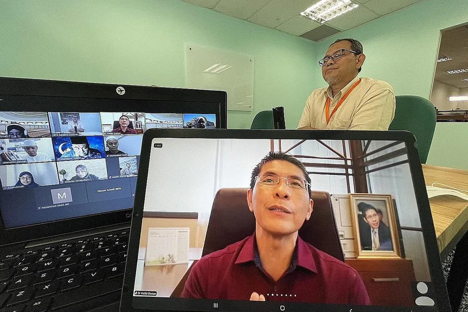 PERANAN PENTING ASATIZAH: Dr Mohamad Maliki (depan) berkata kematangan masyarakat Melayu/Islam dalam menghadapi cabaran krisis ini berkait langsung dengan sumbangan asatizah dalam memberi bimbingan. (Belakang kanan) ialah Encik Suhaimi Mohsen, Editor Naskhah BH/BM. - Foto BH oleh SITI AISYAH NORDIN