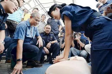CARA MENYELAMAT: Bantuan kecemasan ini yang ditunjukkan kepada Encik Masagos Zulkifli (dua dari kiri) dapat membantu mereka yang mungkin cedera semasa berlaku sebarang insiden yang tidak diingini. - Foto ZAINAL YAHYA