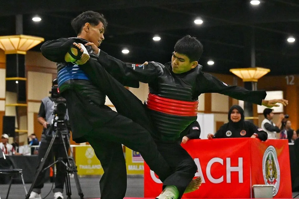 Dhani Andika Razali (kiri) mengatasi pesilat Malaysia, Mohamad Akmal Azman (kanan), 58-44, dalam perlawanan Kelas bawah 45kg Sukan SEA 2025 di Dewan Impact Forum pada 15 Disember.