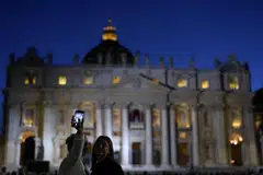 Orang ramai bergambar di depan Gereja St. Peter - tempat mesyuarat para kardinal berlangsung bagi memilih paus atau pope yang baru. 