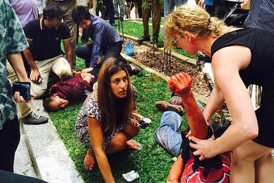 CUBA MEMBANTU: Sebahagian saksi kejadian rompakan cuba menghentikan pendarahan mangsa (kanan) sementara yang lain menahan suspek. - Foto ihsan LEON LEE